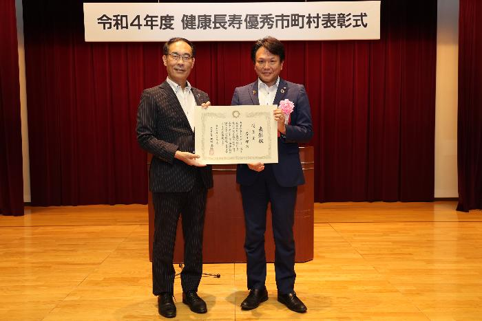 令和4年度健康長寿優秀市町村表彰式で撮影した埼玉県知事と春日部市長の写真