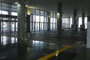 コンクリート地の館内に窓から光が差し込んでいる写真