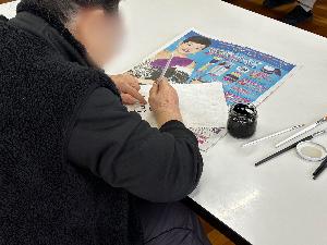 飾り凧の文字を色塗りしている様子