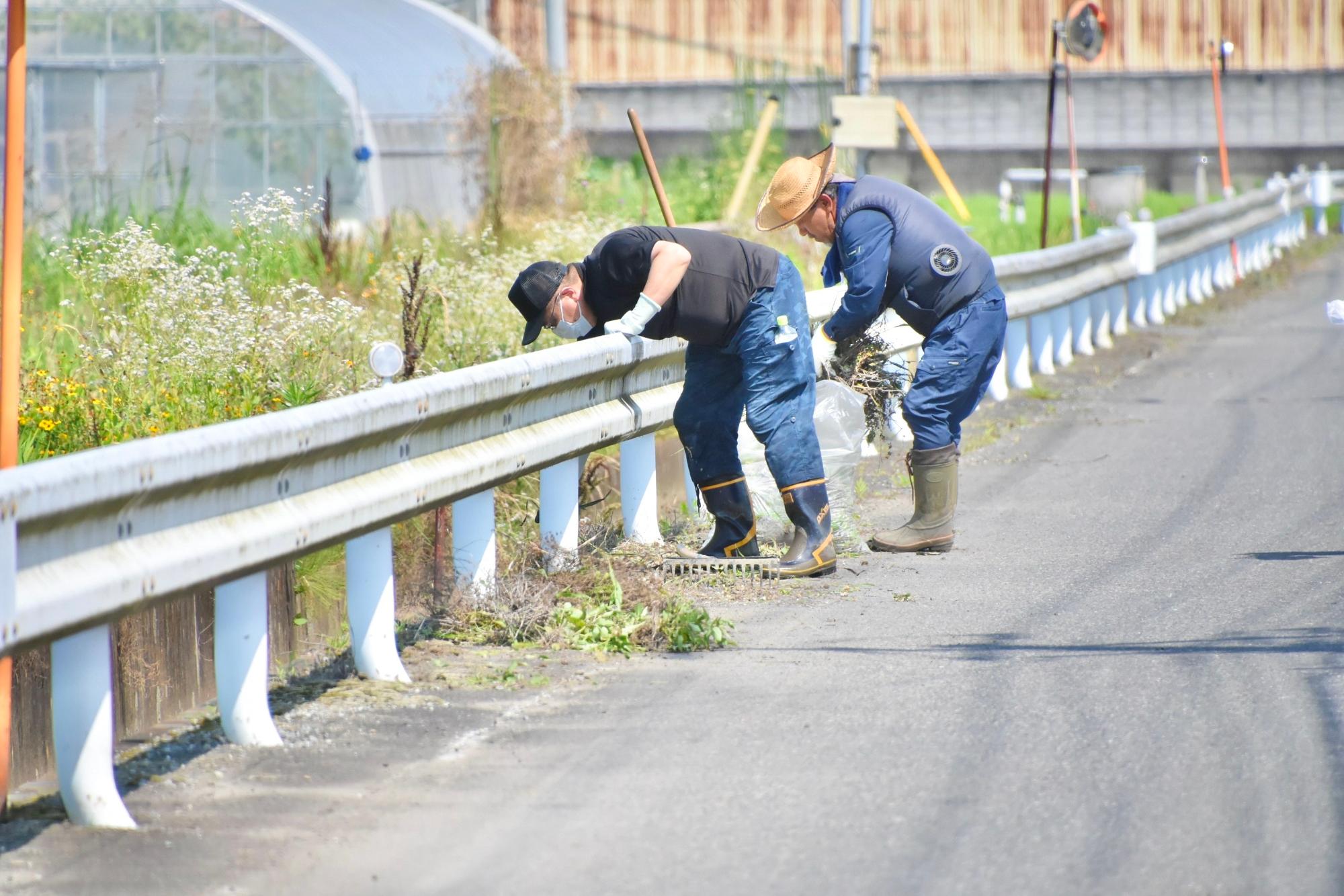 道路脇を走る水路にたまったごみを回収