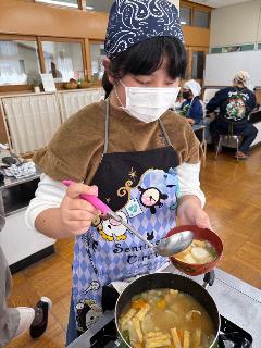 すいとん汁をよそう子ども