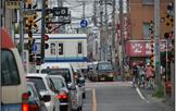 電車が通過したあとも鉄道の踏切が閉まったままで自動車が渋滞を起こしている様子を撮影した写真