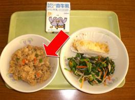 おぼんに載せられた給食のこぎつねごはんのお皿を矢印で示した写真