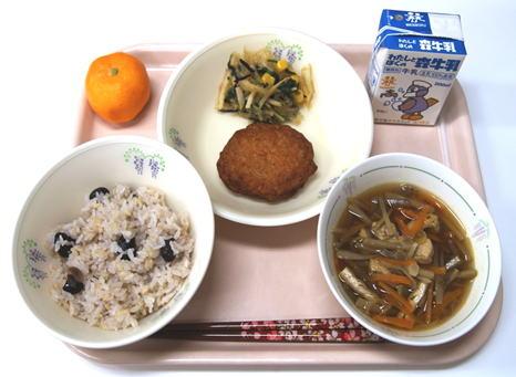 お盆の上にお椀によそられた黒大豆ご飯と金ごま入りきんぴら汁が並び野菜のさつま揚げなども添えられた給食の写真