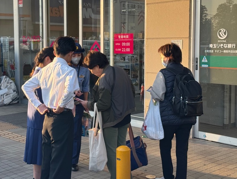 学生が警察官と一緒に利用客へ防犯対策をお話