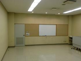 ホワイトボードが真ん中にあり左奥に灰色のドアがある会議室101内を撮影した写真