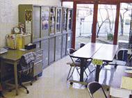 入り口に大きな窓ガラスがあり、机と椅子が配置されている浜川戸ボランティアセンターの室内写真