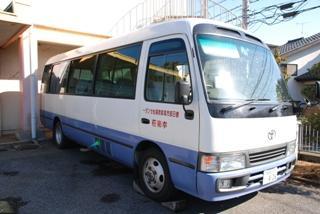 白と紫の車体カラーが目印の幸楽荘への送迎バスの写真