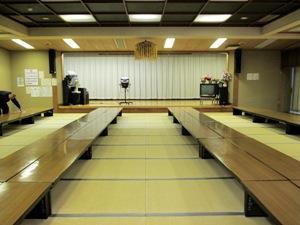 畳敷きの床に折り畳み式の座卓が並ぶ、集会室の内装写真