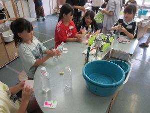 科学教室で児童がペットボトルに飾りを付けている写真