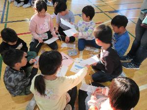 科学教室で児童が紙飛行機を作っている写真