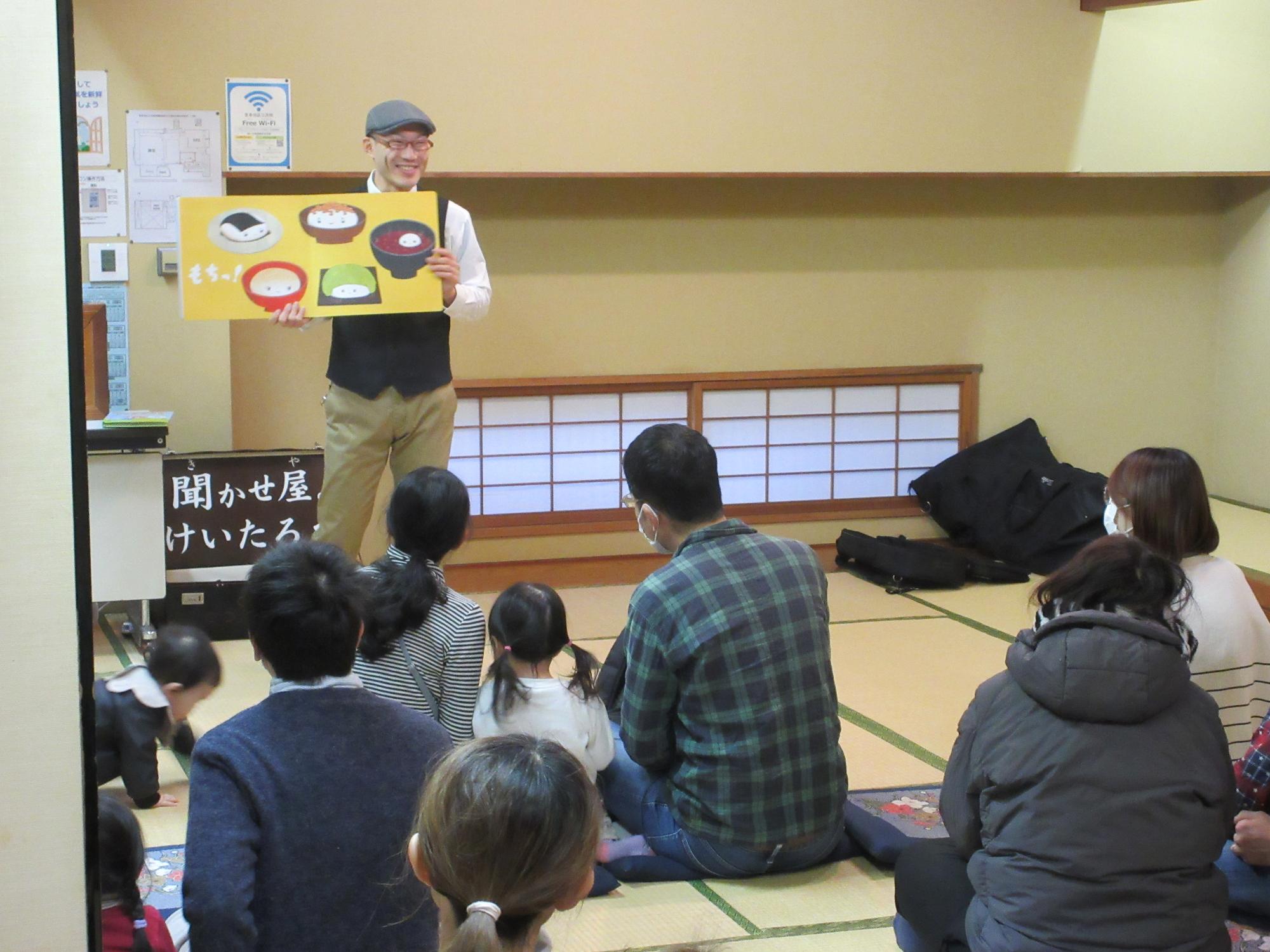 絵本を開いて朗読する読み聞かせ公演会の写真