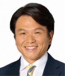 黒いスーツに黄色いネクタイを締めて笑顔で写真に写る岩谷市長の写真