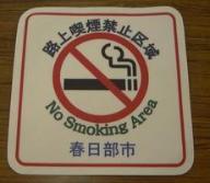 路上喫煙禁止区域という文章と、たばこ禁止のマークが描かれている路面シールの写真