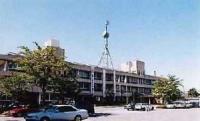 白く3階建てで横幅の広い「埼玉県東部地域振興センター庁舎」の外観と駐車場の写真