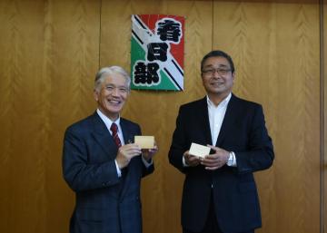 市長を訪問した桐箱工業協同組合会長と市長が桐箱を掲げている写真