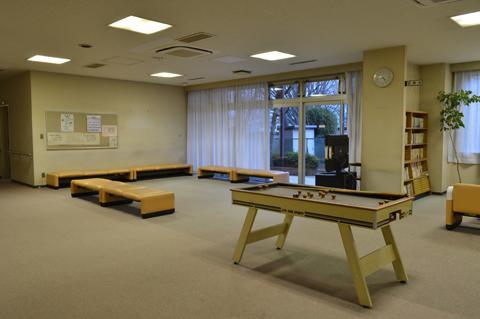 ビリヤード台や本棚が設置されている寿楽荘の談話コーナーの写真