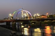 橋がイルミネーションで七色に光っている写真
