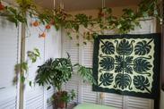 植物のタペストリー、フェイクグリーンのガーランド、観葉植物で装飾されている部屋の一角の写真