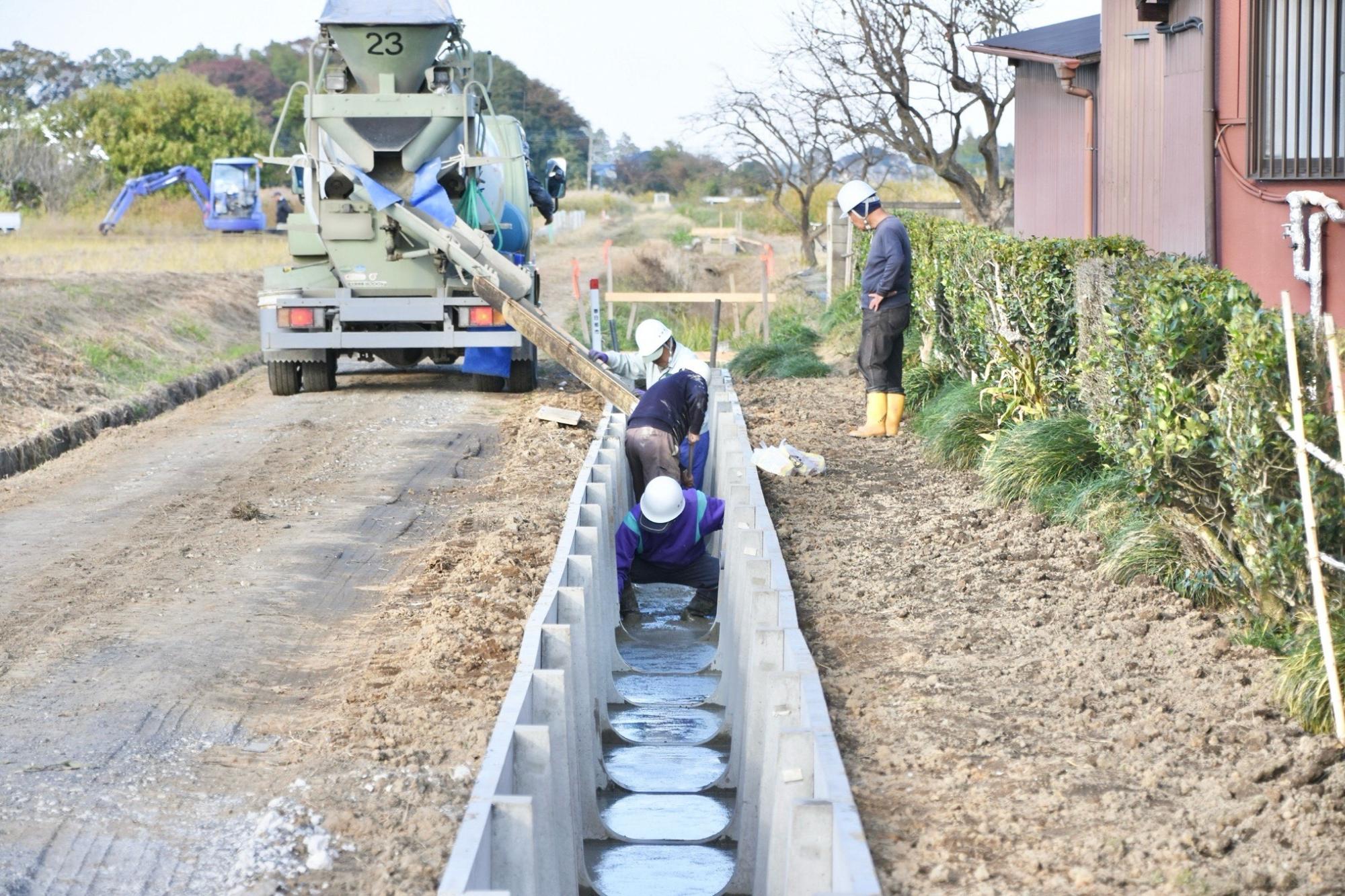 水路の底に入れたコンクリートを平らにならす様子