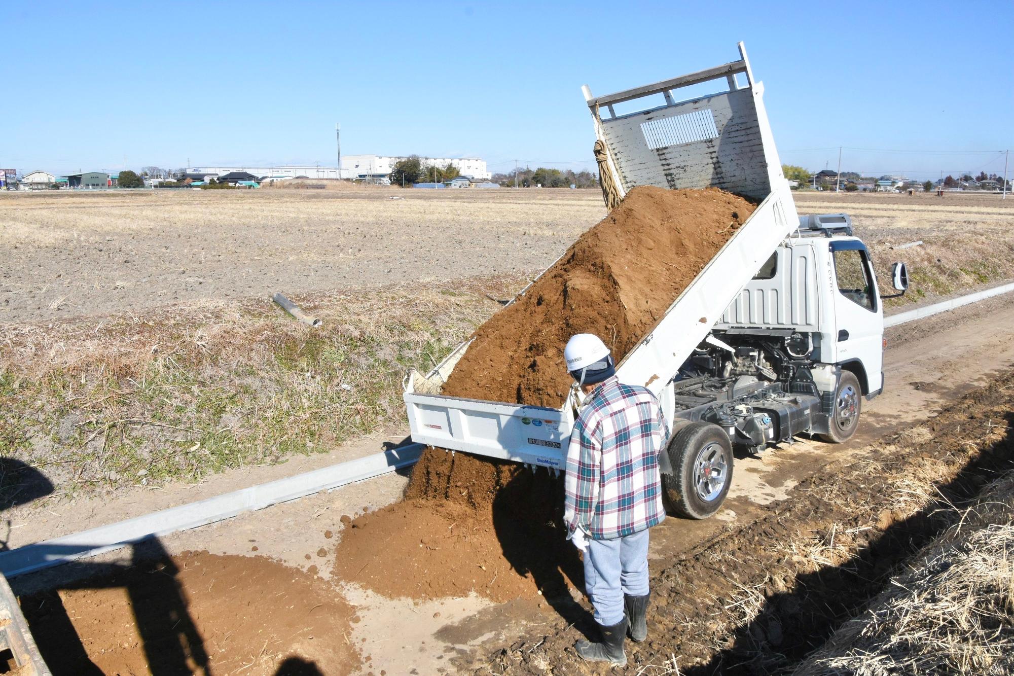 トラックから土を降ろす様子