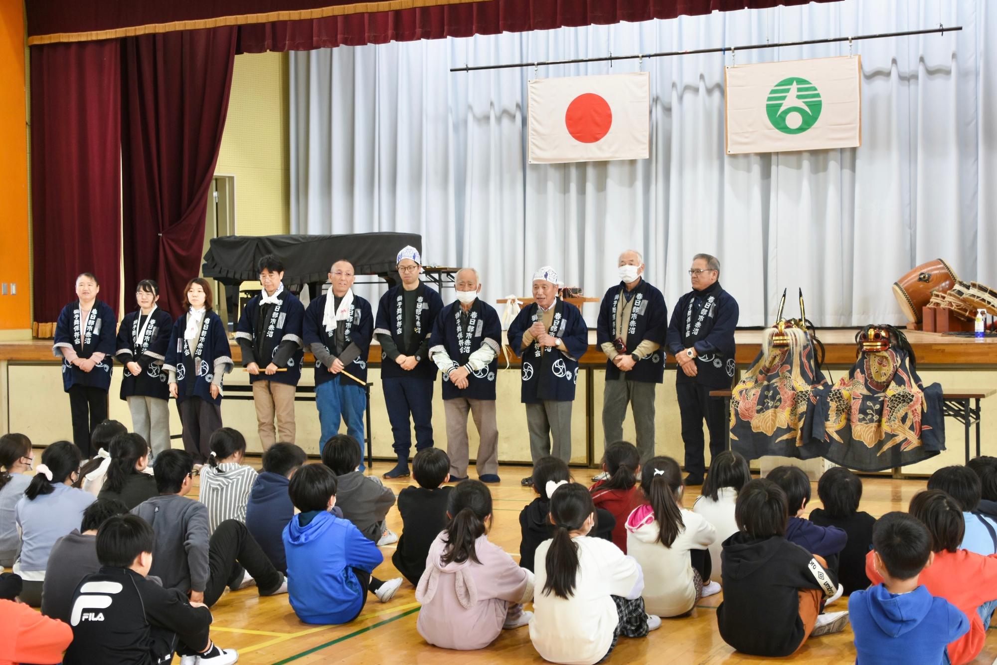 こどもたちに獅子舞について話す保存会メンバー