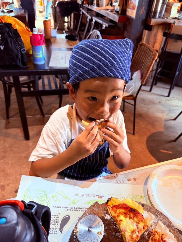 手作りピザを食べる子ども