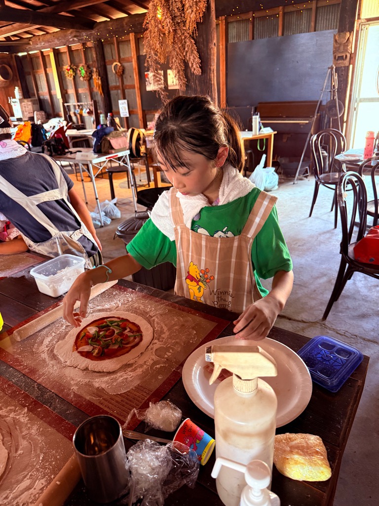ピザにトッピングをする子ども