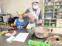 すいとん汁を器によそう親子
