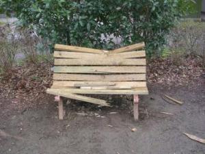 木製ベンチの板材が折られて壊されている公園のベンチの写真