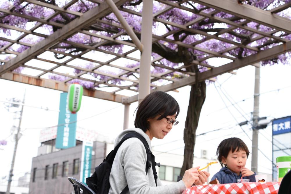 藤棚の下での親子の食事風景