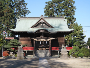 木々に囲まれた藤塚香取神社の本殿とその左右前方に対面に建てられている狛犬像の写真