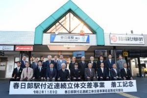 春日部駅東口前にて着工記念の横断幕を広げた出席者の集合写真