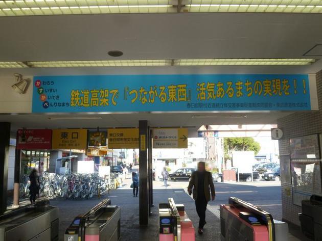 春日部駅東口改札口上部に貼られた「鉄道高架で『つながる東西』活気あるまちの実現を！」のPR看板の写真