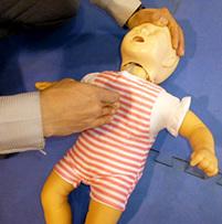 赤ちゃん人形の胸の中央のあたりを指先で押さえている写真