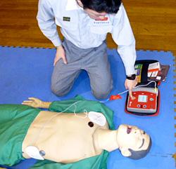 AEDのショックボタンを押す男性の写真