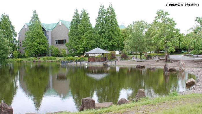池の周りに砂利や東屋などがある庄和総合公園の風景写真