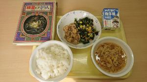 鳥飯など3皿が並んだ給食と書籍が並べて置かれている写真