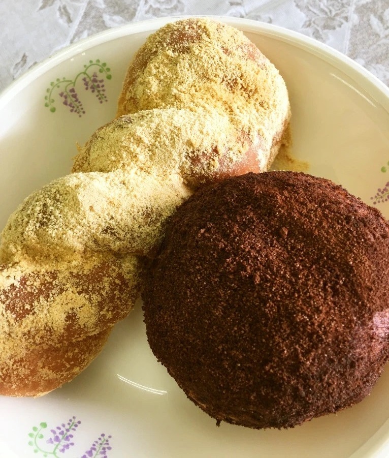 ツイストパンを揚げきなこがまぶされた揚げパンと丸いパンを揚げココアがまぶされた揚げパンの写真