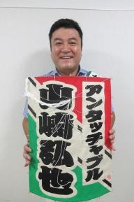 名前入り凧を手にもって笑顔をみせる山崎さんの写真