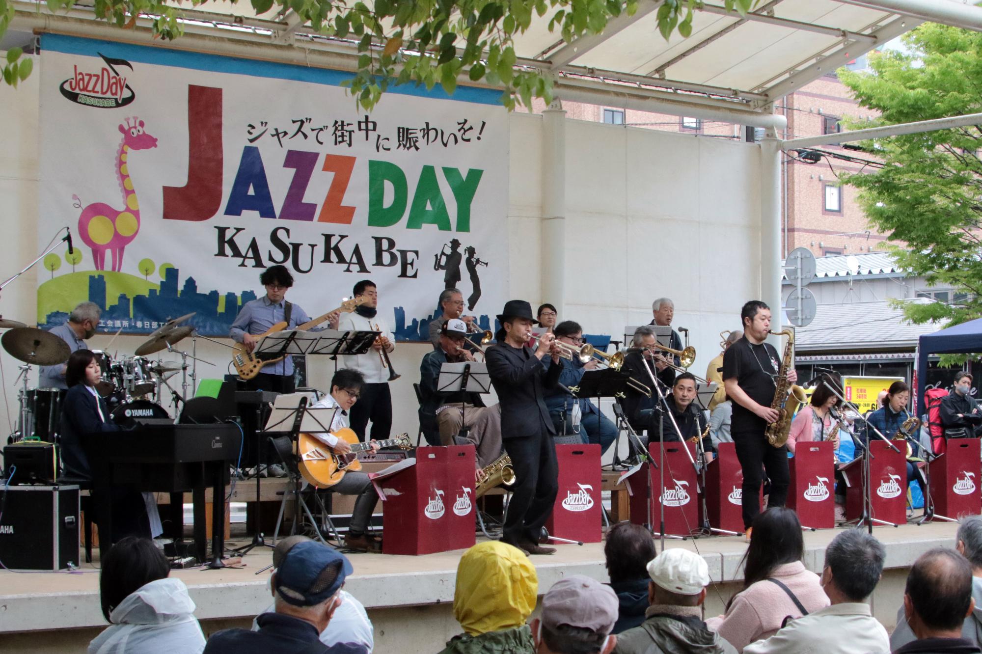 出演者がステージ上に並んで演奏している写真