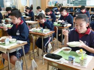 教室の前方から給食を食べている生徒たちを撮影した写真