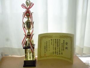 赤いリボンがついた調理コンクールのトロフィーと、賞状が並べて置かれている写真