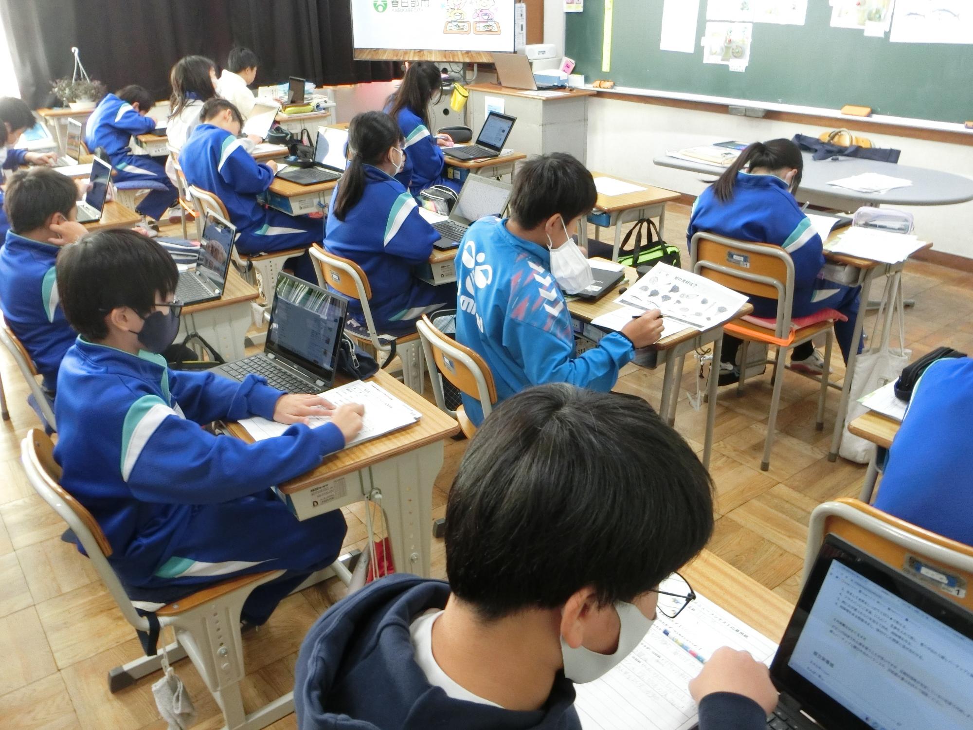 教室でタブレットを使用し、授業を受ける生徒たちの写真