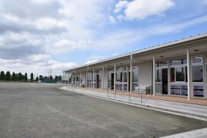 青空と白い雲、江戸川小中学校新校舎の一角をグラウンド側から撮影した写真
