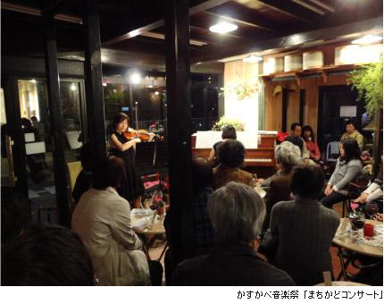 飲食店の店内でバイオリンを弾いている女性と観客たちの写真に、かすかべ音楽祭「まちかどコンサート」と説明書きされている写真