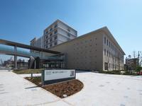 茶色い壁の大きな建物が建っている、市立医療センターの外観の写真