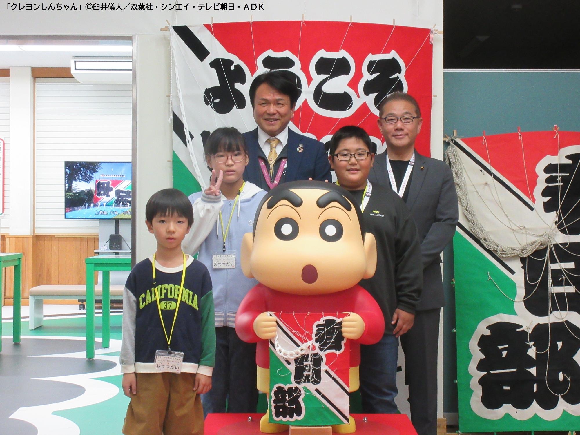 お披露目されたモニュメントと写るお手伝いのこどもたちと市長・議長