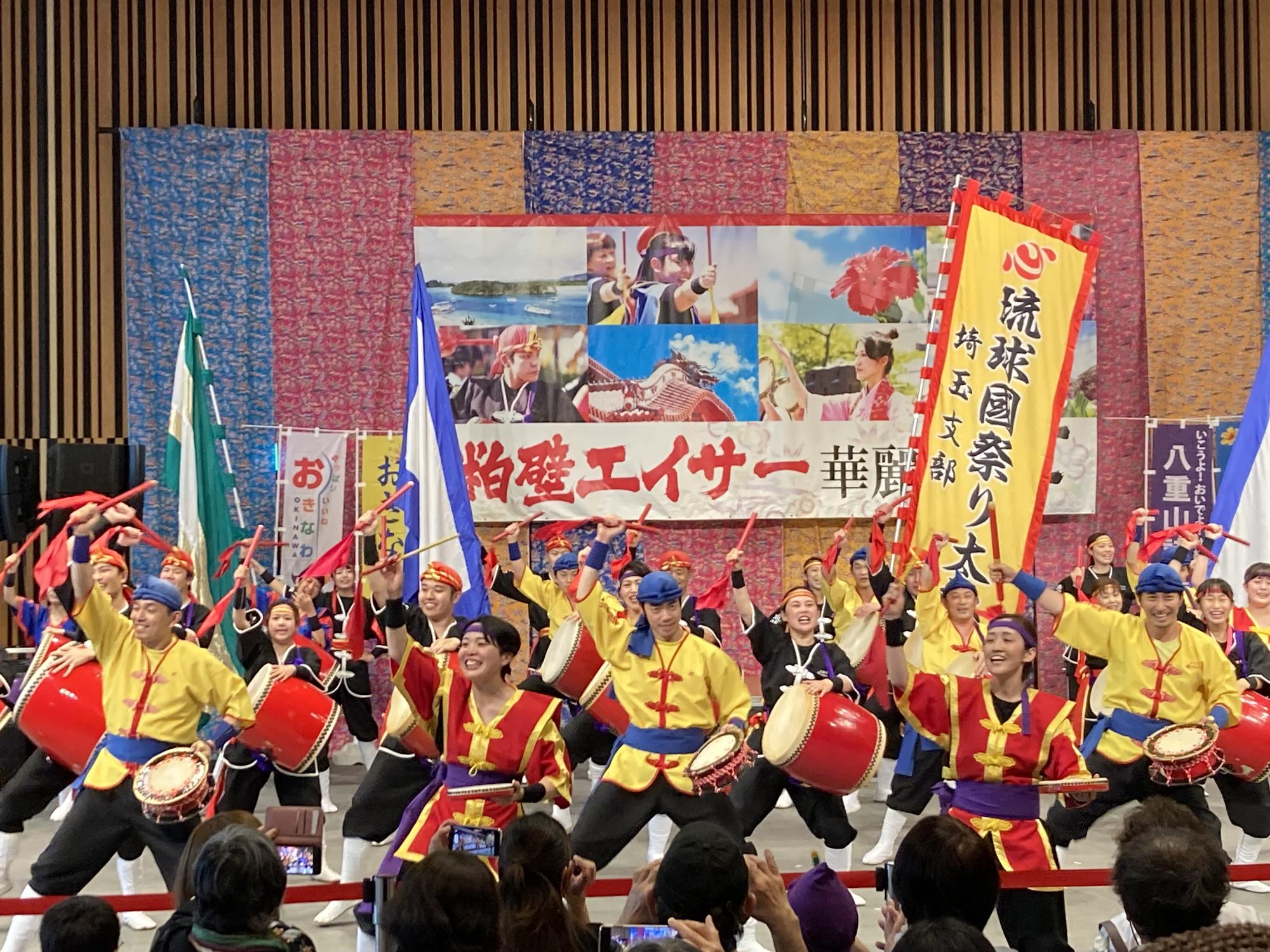 赤いバチと太鼓を持ち、エイサーを踊る人々の写真