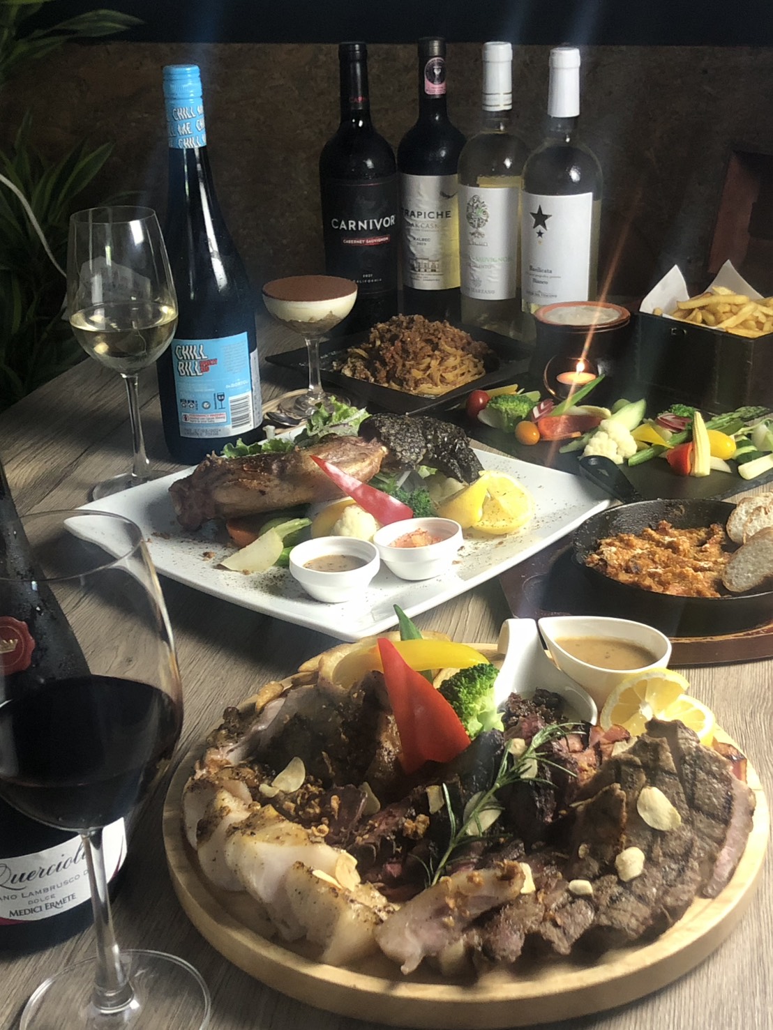 54BALで提供されている肉料理やパスタなどの料理とワインの写真